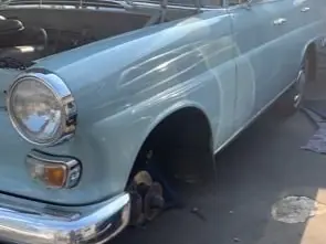 Ein hellblauer Mercedes-Benz Oldtimer mit geöffneter Motorhaube.