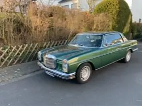 Ein grüner Mercedes-Benz Oldtimer am Straßenrand.