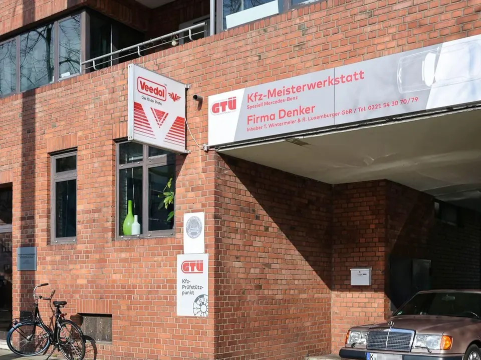 Seitenansicht des Werkstattgebäudes mit parkendem Fahrzeug.