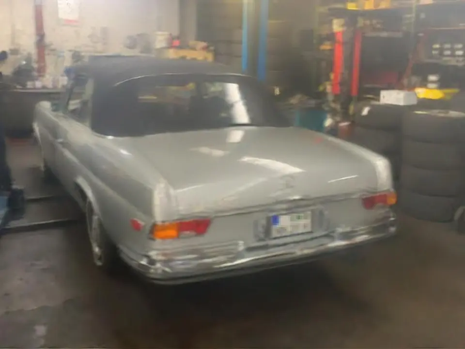Heckansicht eines silbernen Mercedes-Benz Oldtimers in der Werkstatt.