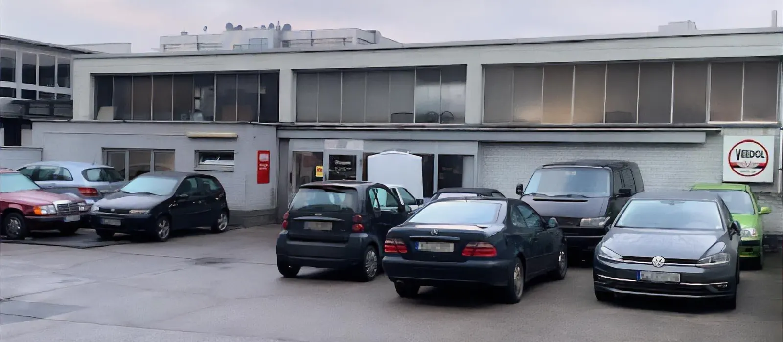 Zahlreiche Kundenfahrzeuge auf dem Hof der Werkstatt in Köln.