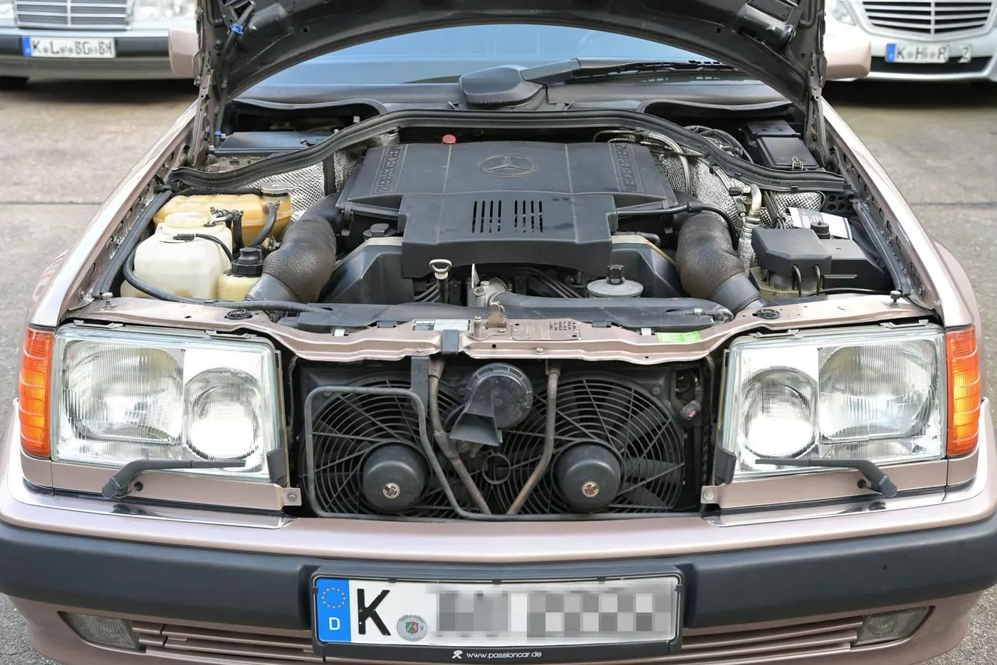 Ein Fahrzeug mit geöffneter Motorhaube und Kölner Kennzeichen in der Werkstatt.
